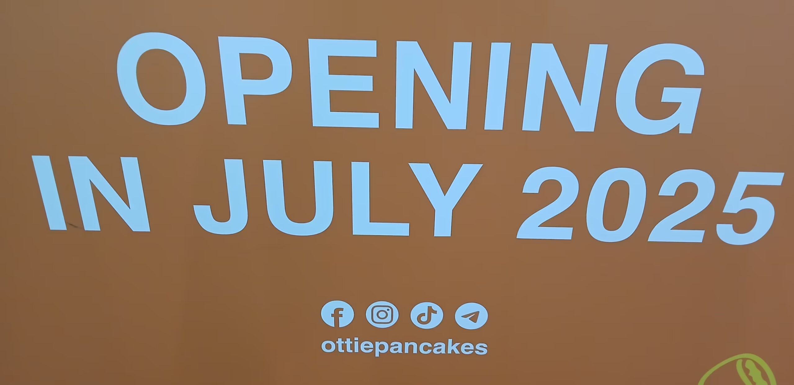Ottie Pancakes - Orange with white lettering: OPENING IN JULY 2025 Underneath socialmedia icons (Facebook, Instagram, TikTok, Telegram) ottiepancakes.