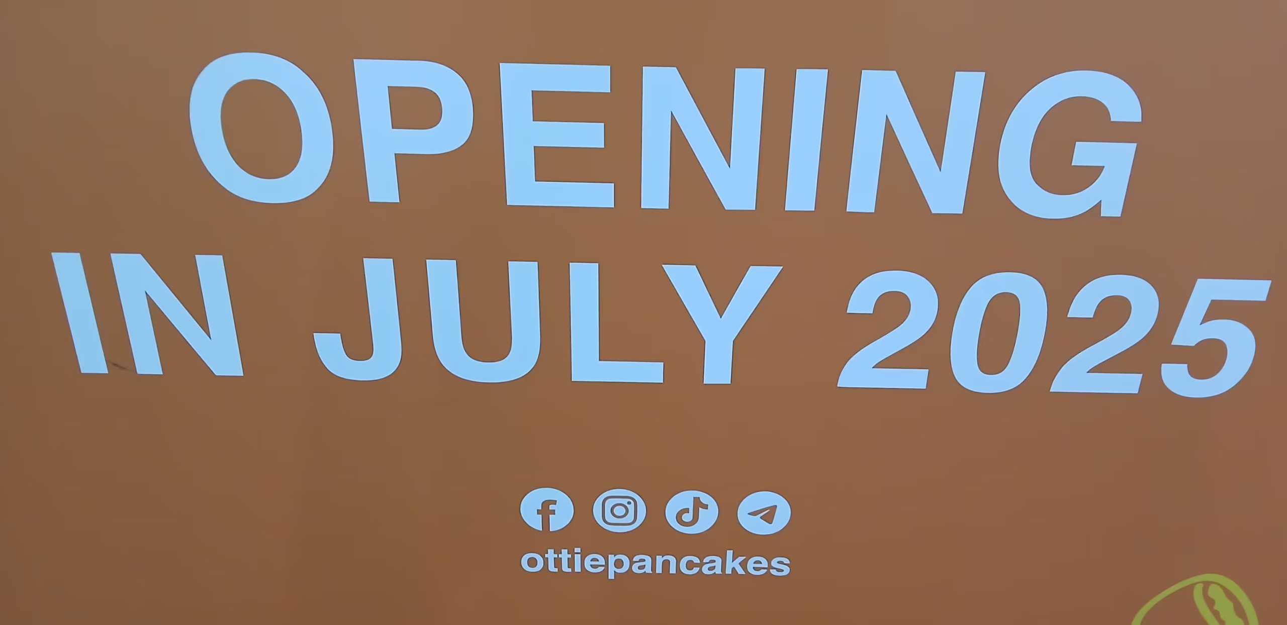 Ottie Pancakes - Orange with white lettering: OPENING IN JULY 2025 Underneath socialmedia icons (Facebook, Instagram, TikTok, Telegram) ottiepancakes.